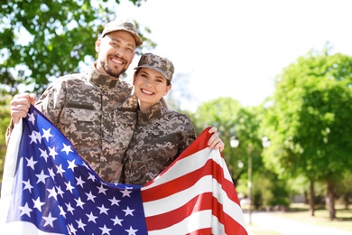 Military couple with American flag in park