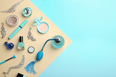 Flat lay composition with perfume bottles, jewelry and cosmetic products on light blue background, space for text