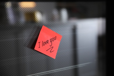 Photo of Sticky note with handwritten text I Love You attached to oven door in kitchen. Romantic message