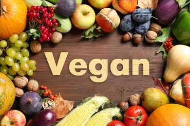 Image of Word Vegan, fresh vegetables and fruits on wooden background, flat lay