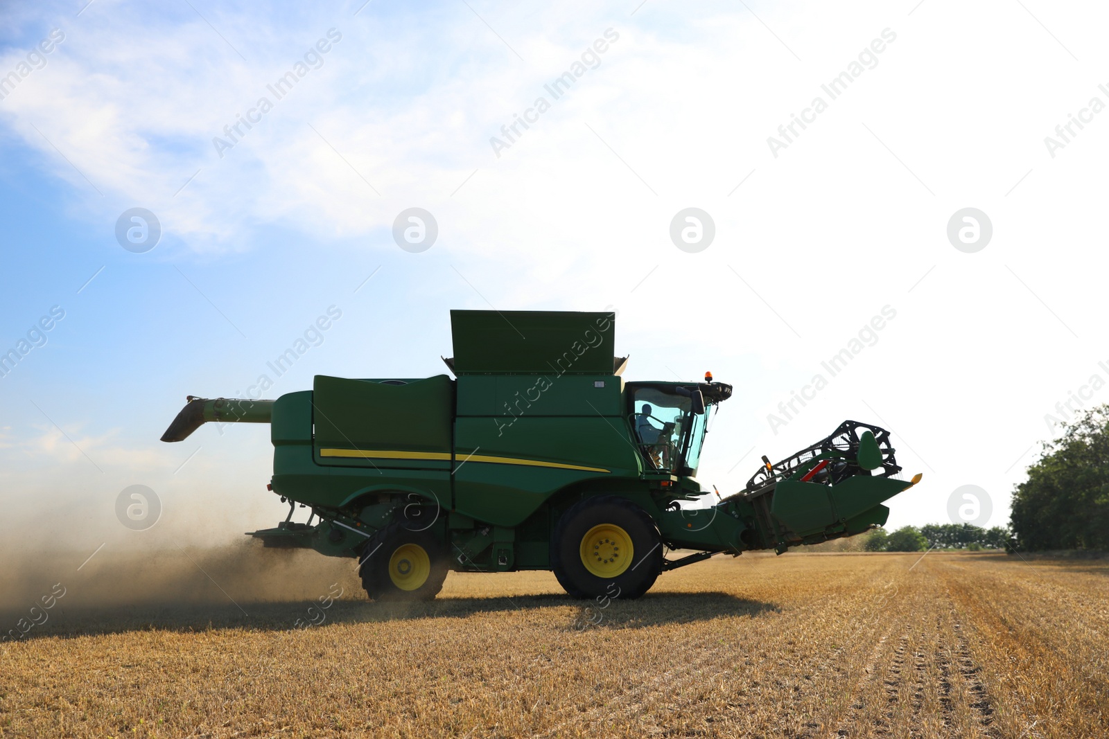 Photo of Modern combine harvester working in agricultural field