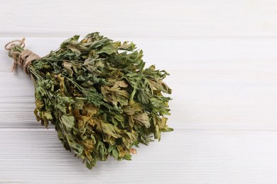 Photo of Bunch of dry parsley on white wooden table, space for text