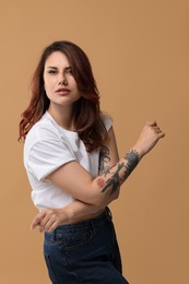 Photo of Portrait of beautiful tattooed woman on beige background