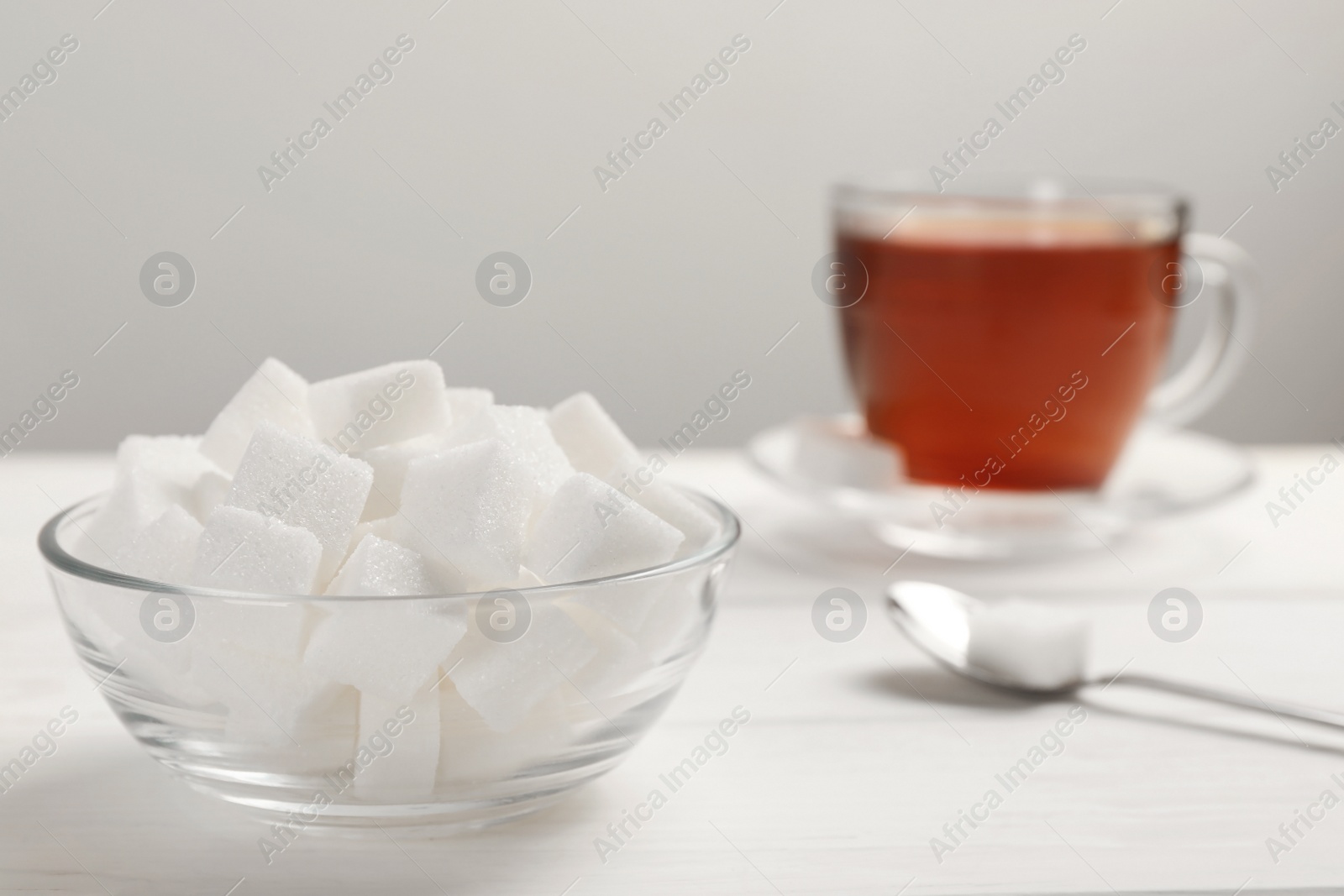 Photo of Bowl with sugar cubes served on white table