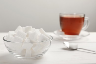 Bowl with sugar cubes served on white table