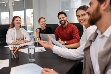 Photo of Team of employees working together in office