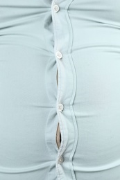 Photo of Overweight man with large belly in tight shirt , closeup