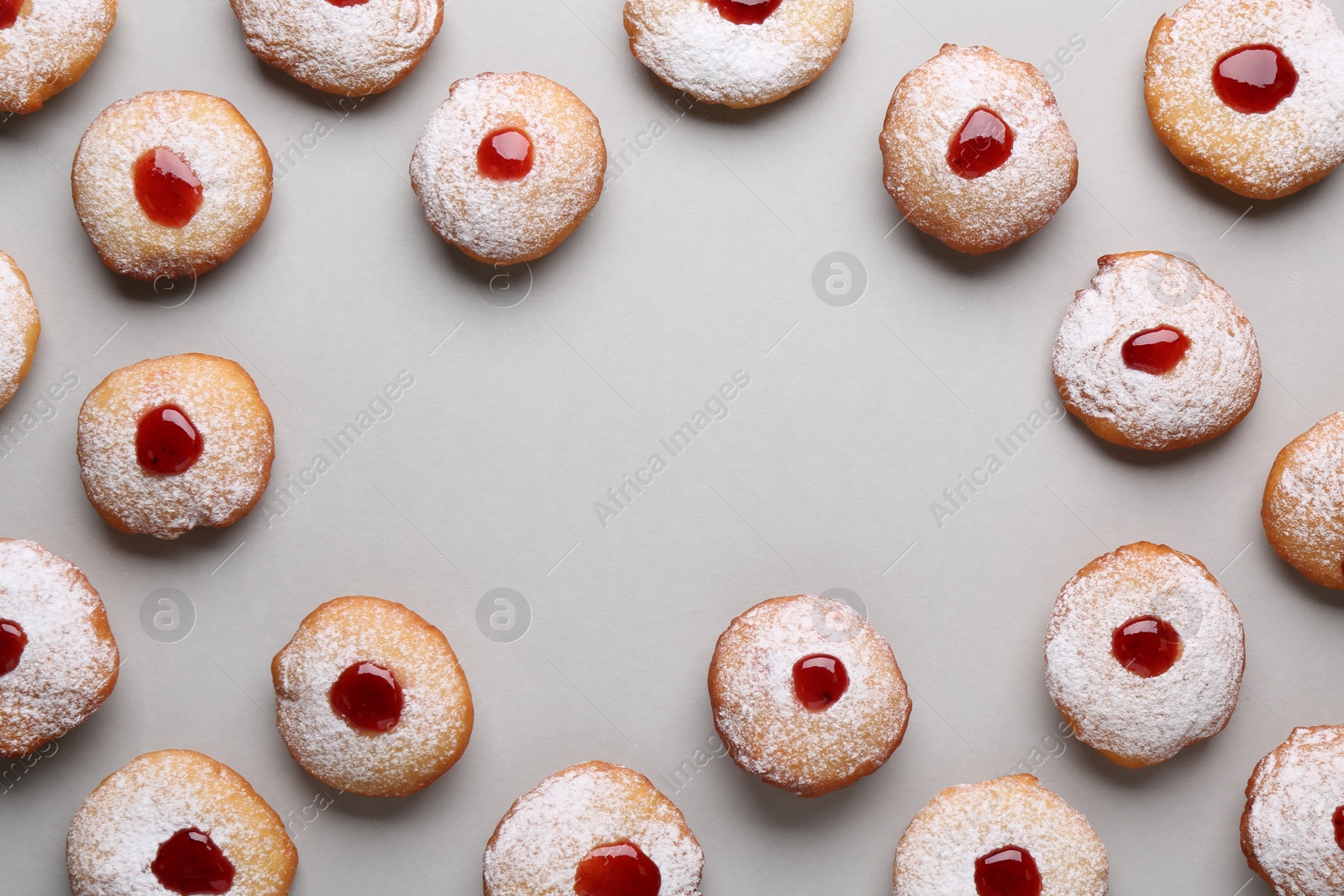 Photo of Frame of Hanukkah donuts with jelly and powdered sugar on light grey background, flat lay. Space for text