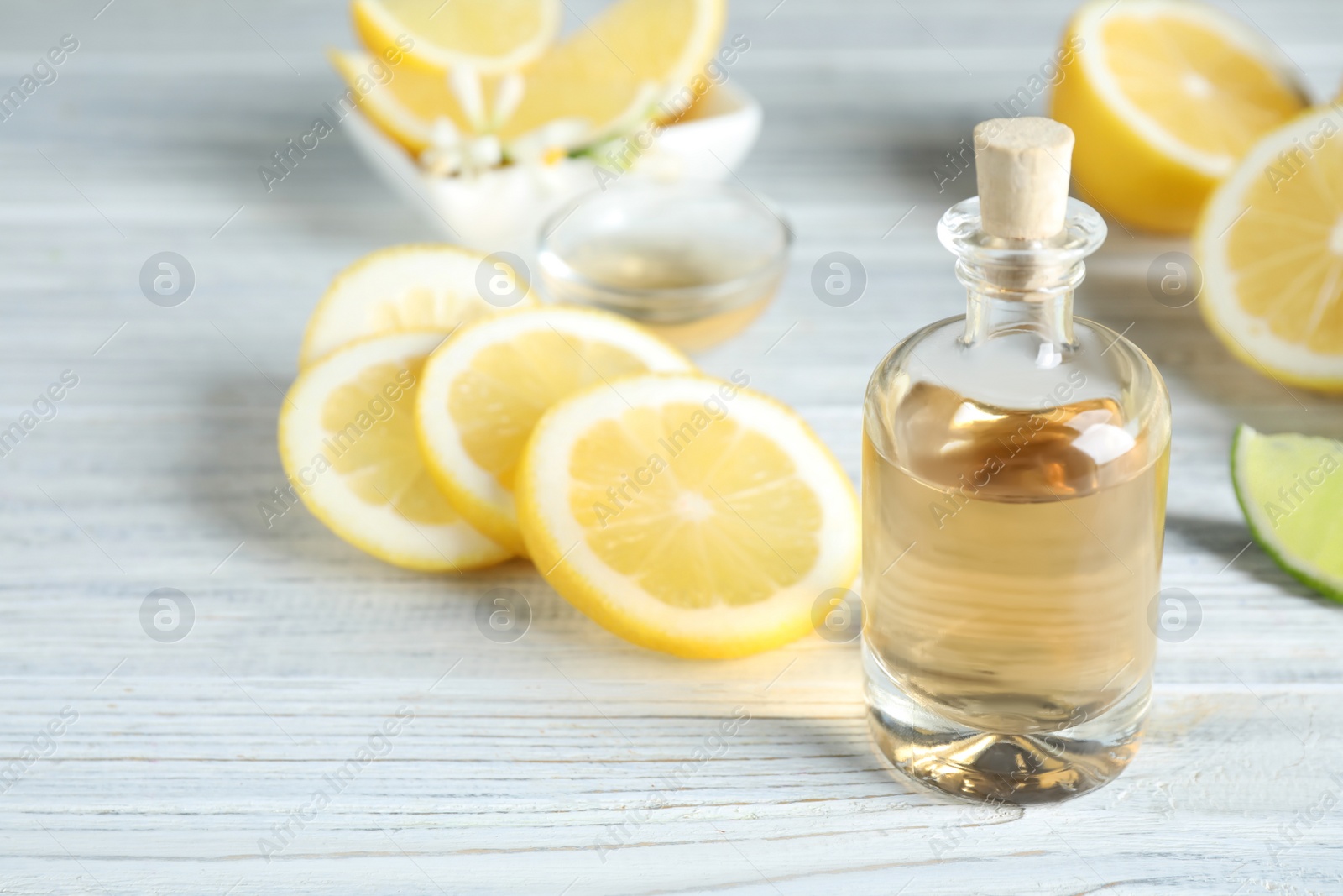 Photo of Citrus essential oil on white wooden table