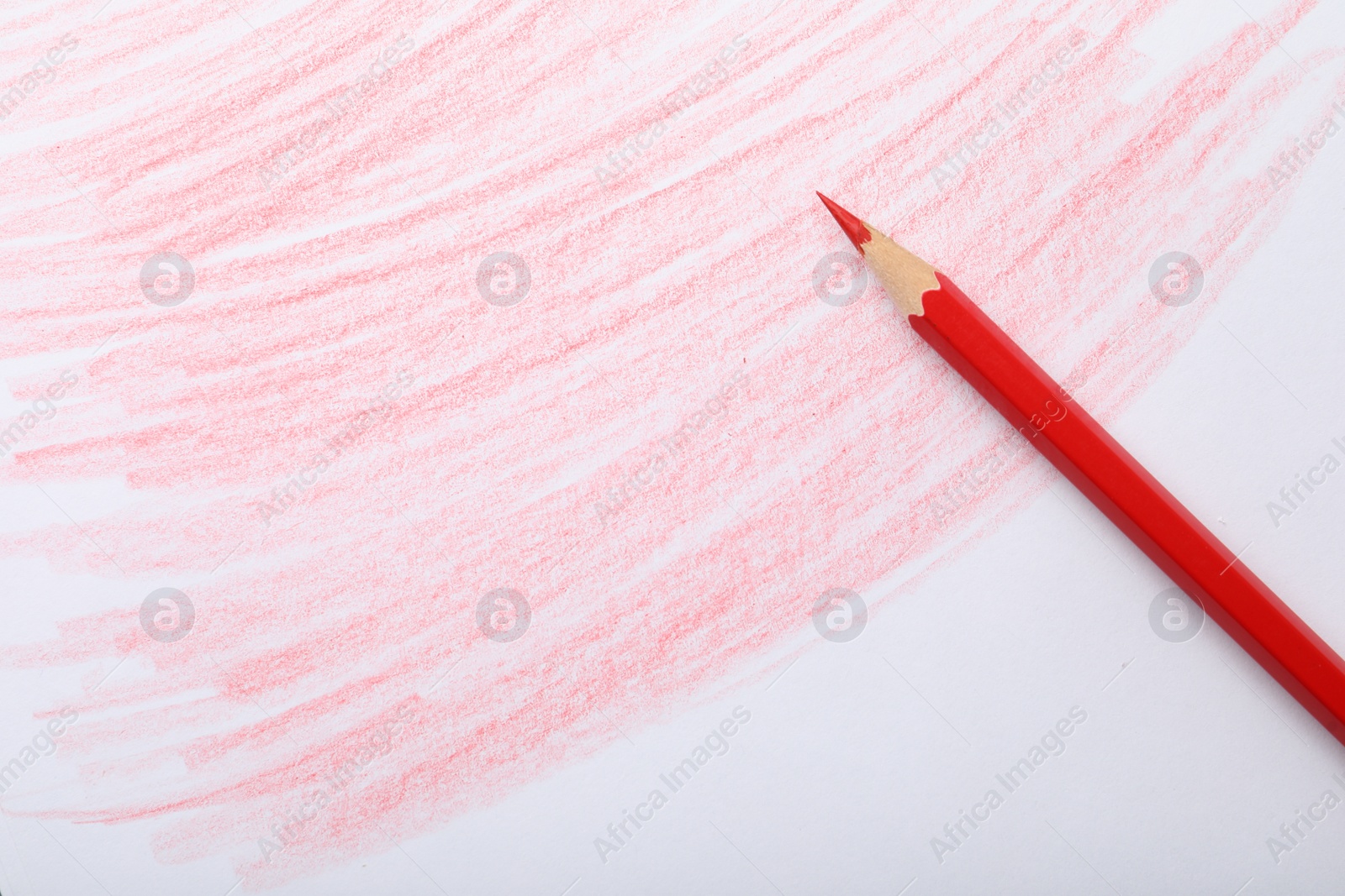 Photo of Red pencil on sheet of paper with drawing, top view