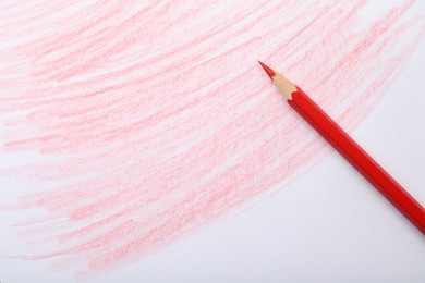 Photo of Red pencil on sheet of paper with drawing, top view