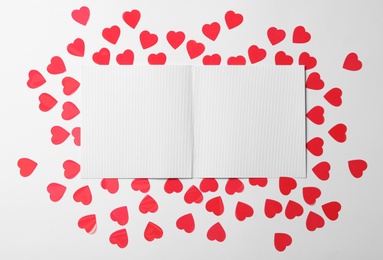 Photo of Blank card and paper hearts on white background, flat lay with space for text. Valentine's Day celebration