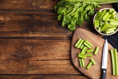 Fresh ripe green celery on wooden table, flat lay. Space for text