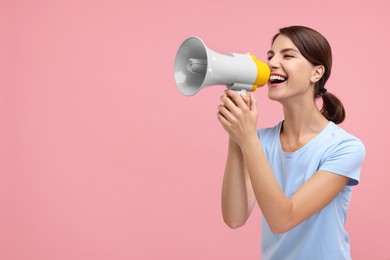 Photo of Special promotion. Young woman shouting in megaphone on pink background, space for text