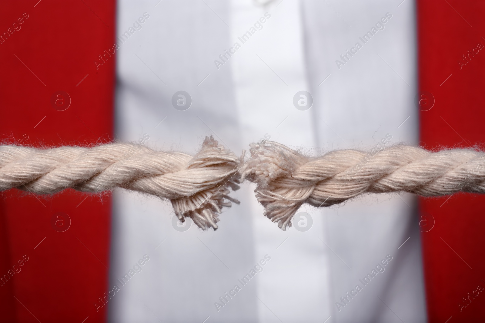 Photo of Woman pulling frayed rope with tension, closeup