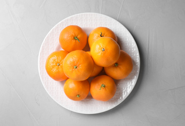 Photo of Fresh ripe tangerines on grey table, top view