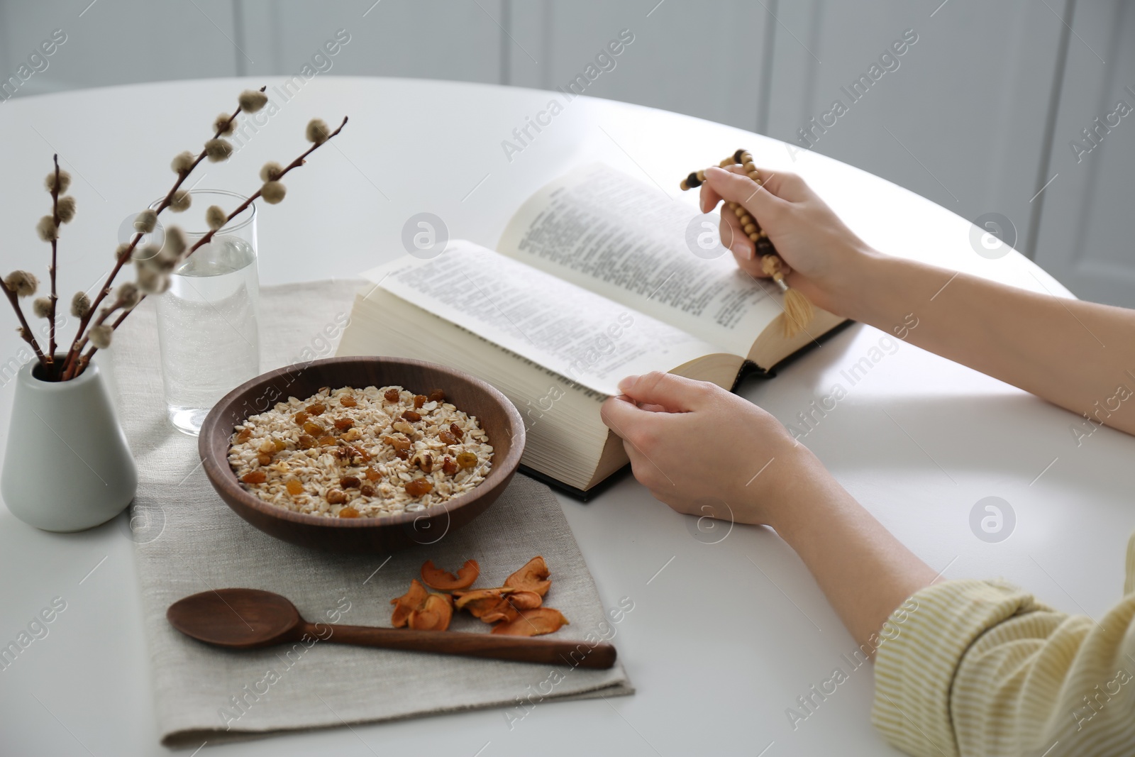 Photo of Woman with Bible having dinner at home, closeup. Great Lent season