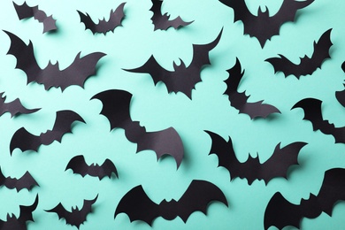 Photo of Many black paper bats on light blue background, flat lay. Halloween decor