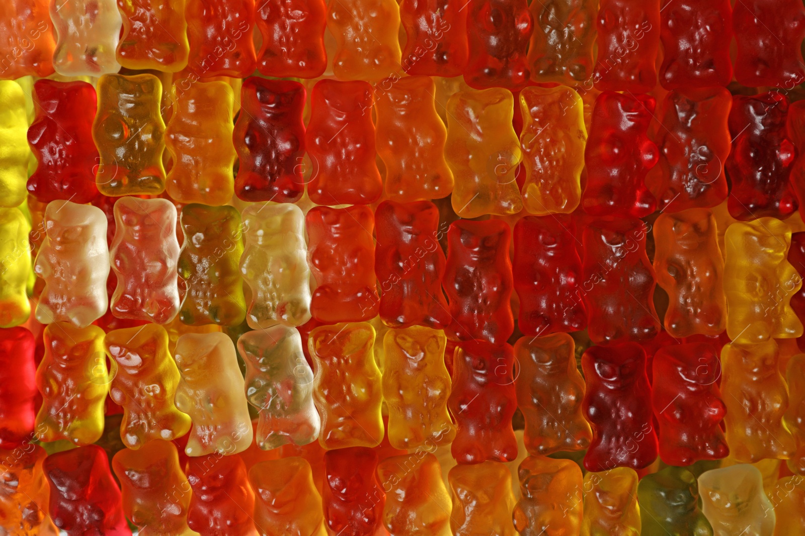 Photo of Many delicious jelly bears as background, top view