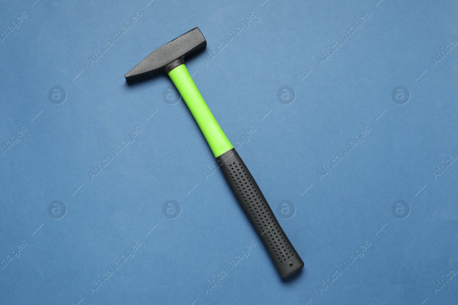 Photo of New hammer with rubber handle on blue background, top view