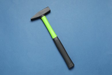 New hammer with rubber handle on blue background, top view