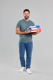 Photo of Happy man with folders on light gray background