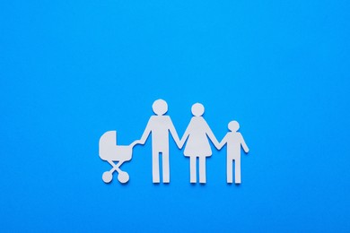 Photo of Paper family cutout on light blue background, top view. Insurance concept