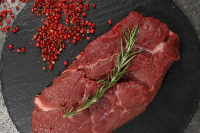 Photo of Piece of raw beef meat, rosemary and red peppercorns on table, flat lay