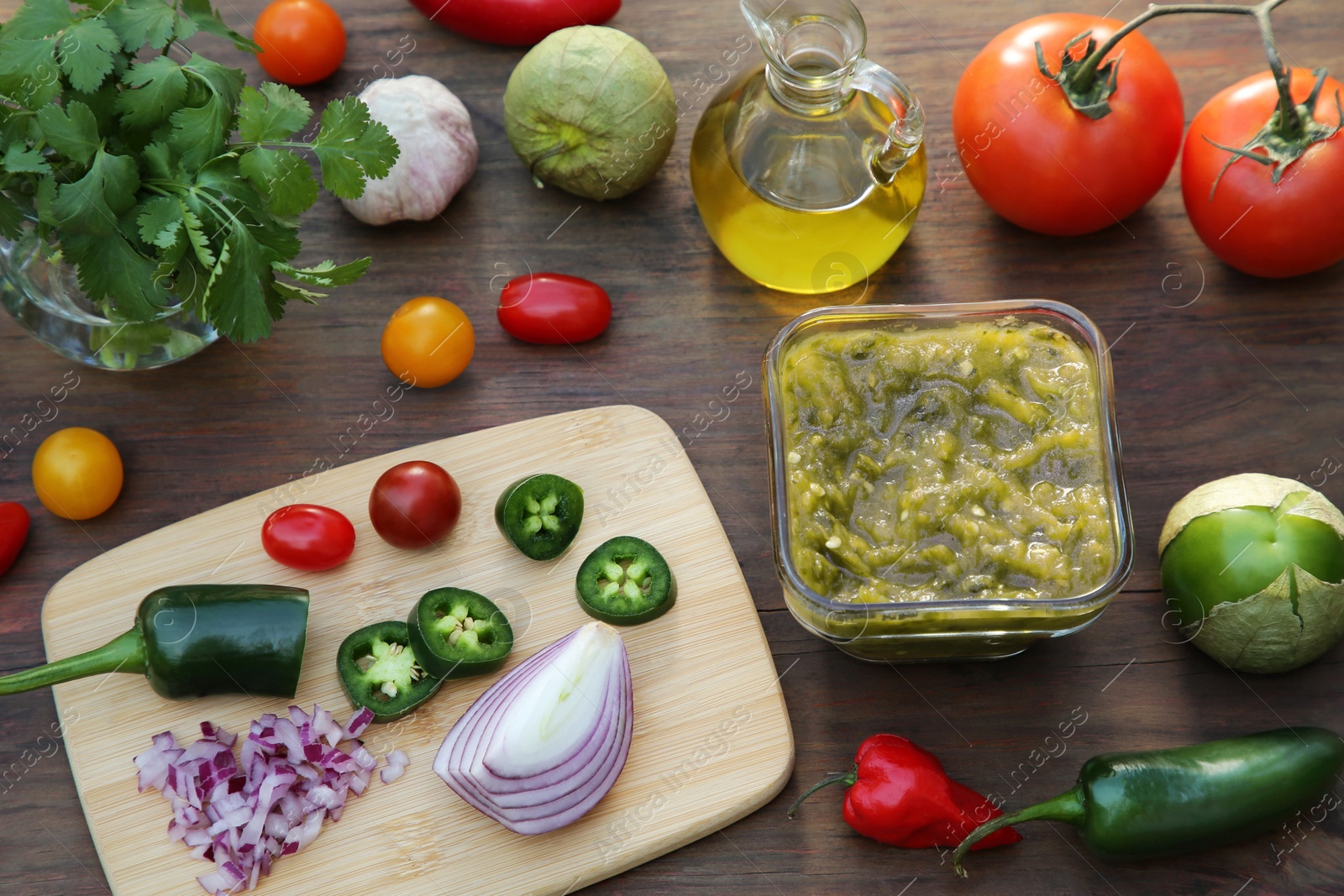 Photo of Tasty salsa sauce and ingredients on wooden table, above view