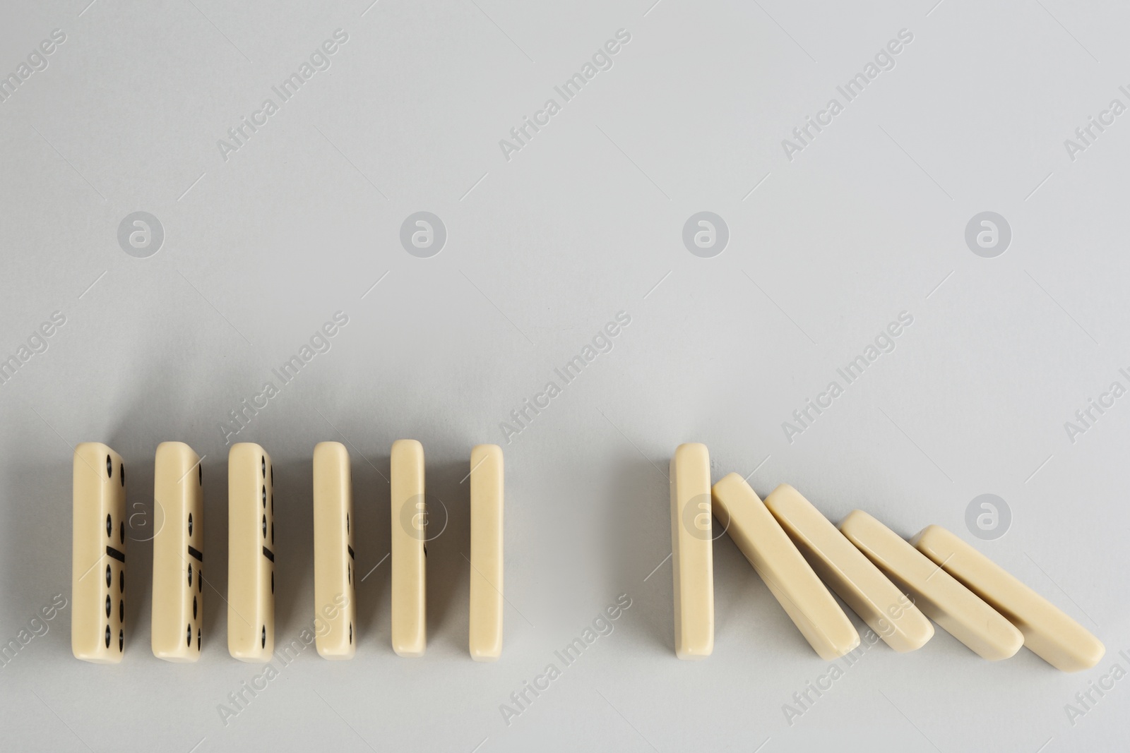 Photo of Light domino tiles on white background, flat lay. Space for text