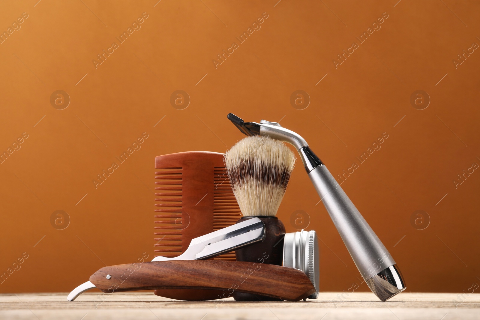 Photo of Moustache and beard styling tools on wooden table