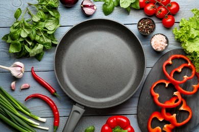 Photo of Flat lay composition with frying pan and fresh products on grey wooden table