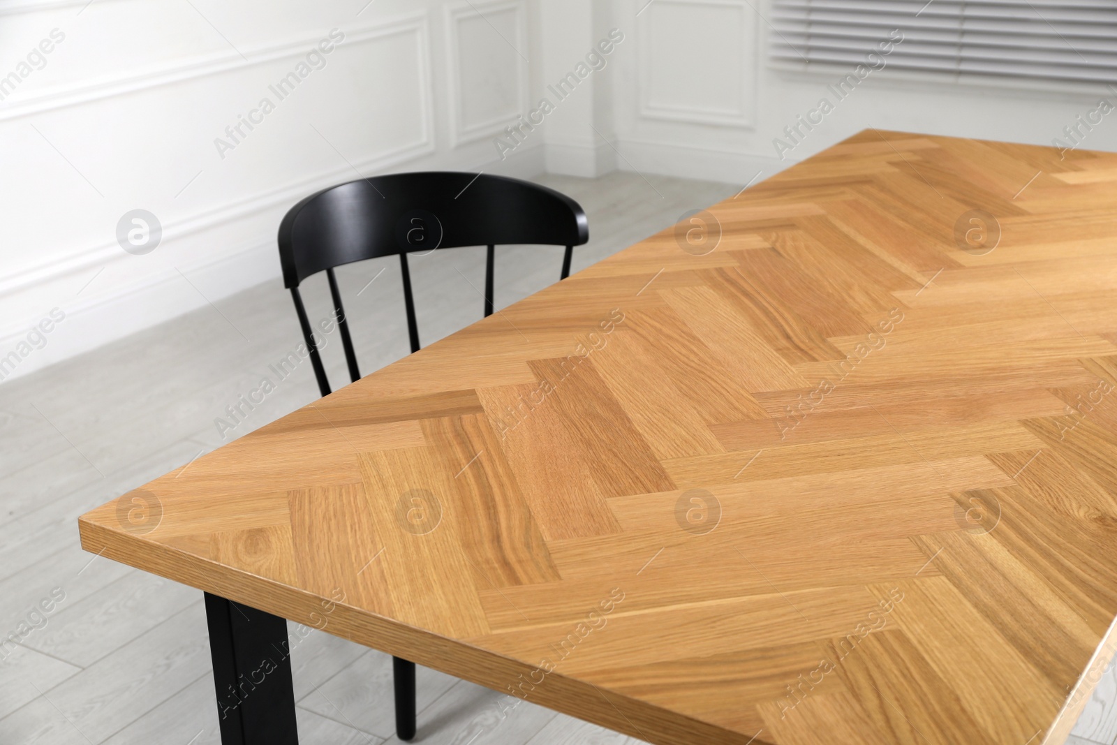 Photo of Wooden table and black chair in room. Interior design