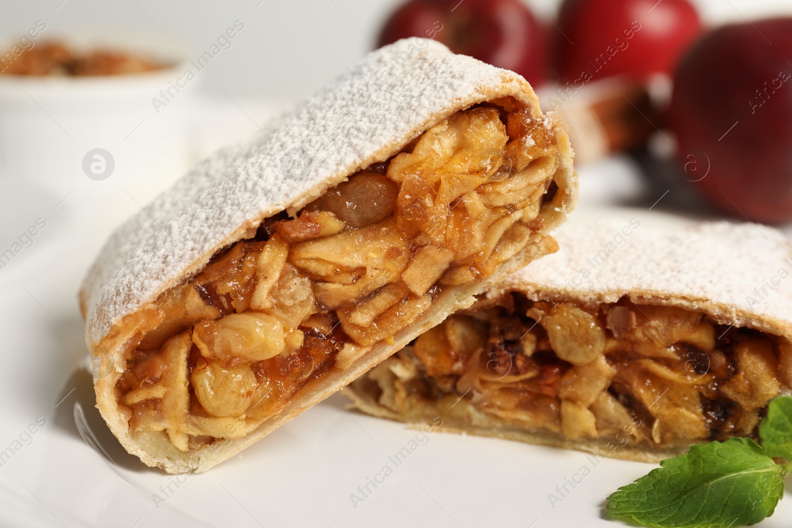 Photo of Delicious strudel with apples, nuts and raisins on plate, closeup