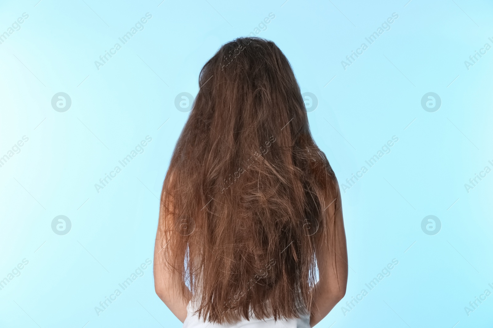 Photo of Woman with tangled brown hair on color background
