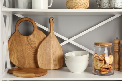 Wooden cutting boards, bowls and french palmier cookies on shelving unit