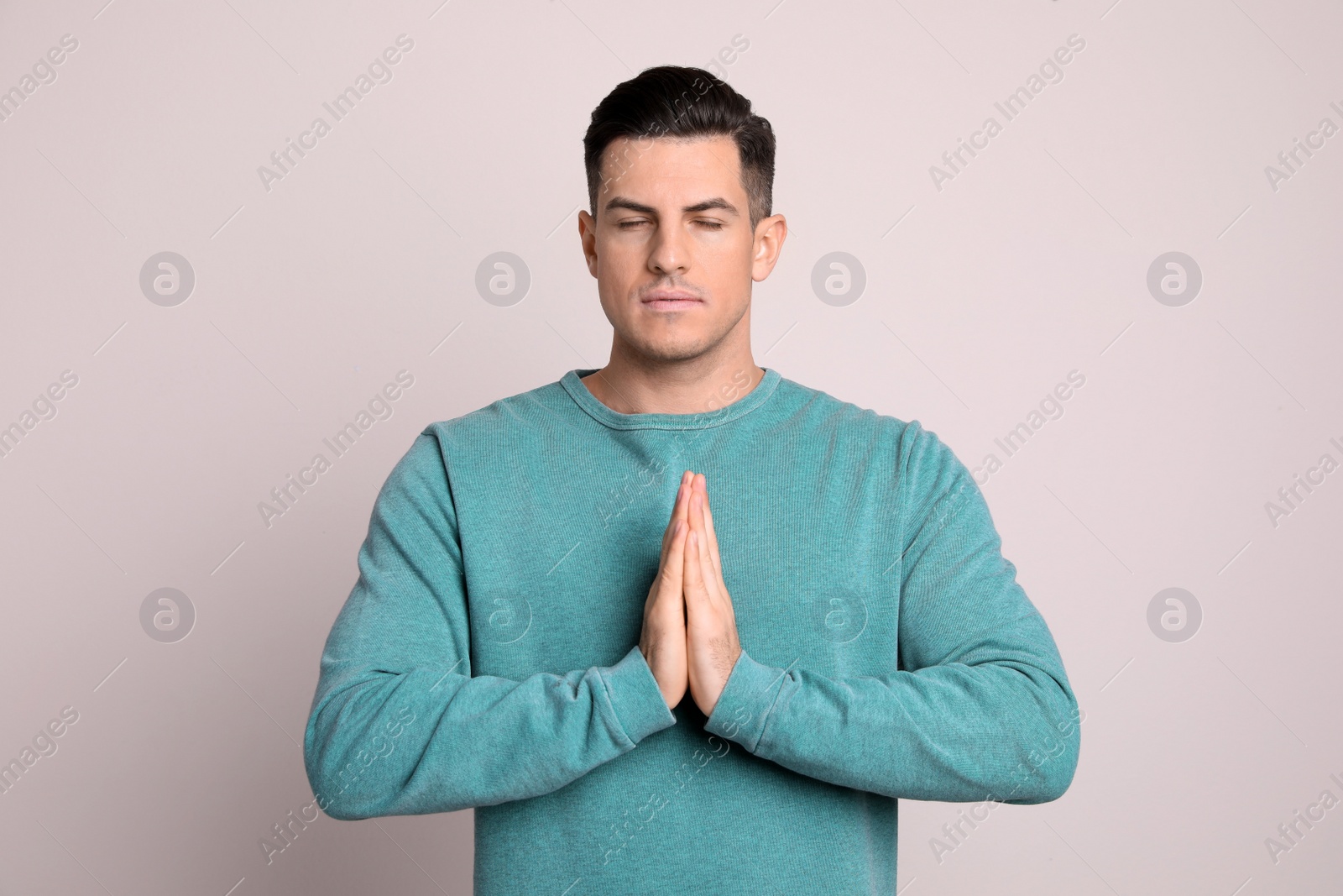 Photo of Man meditating on light background. Stress relief exercise