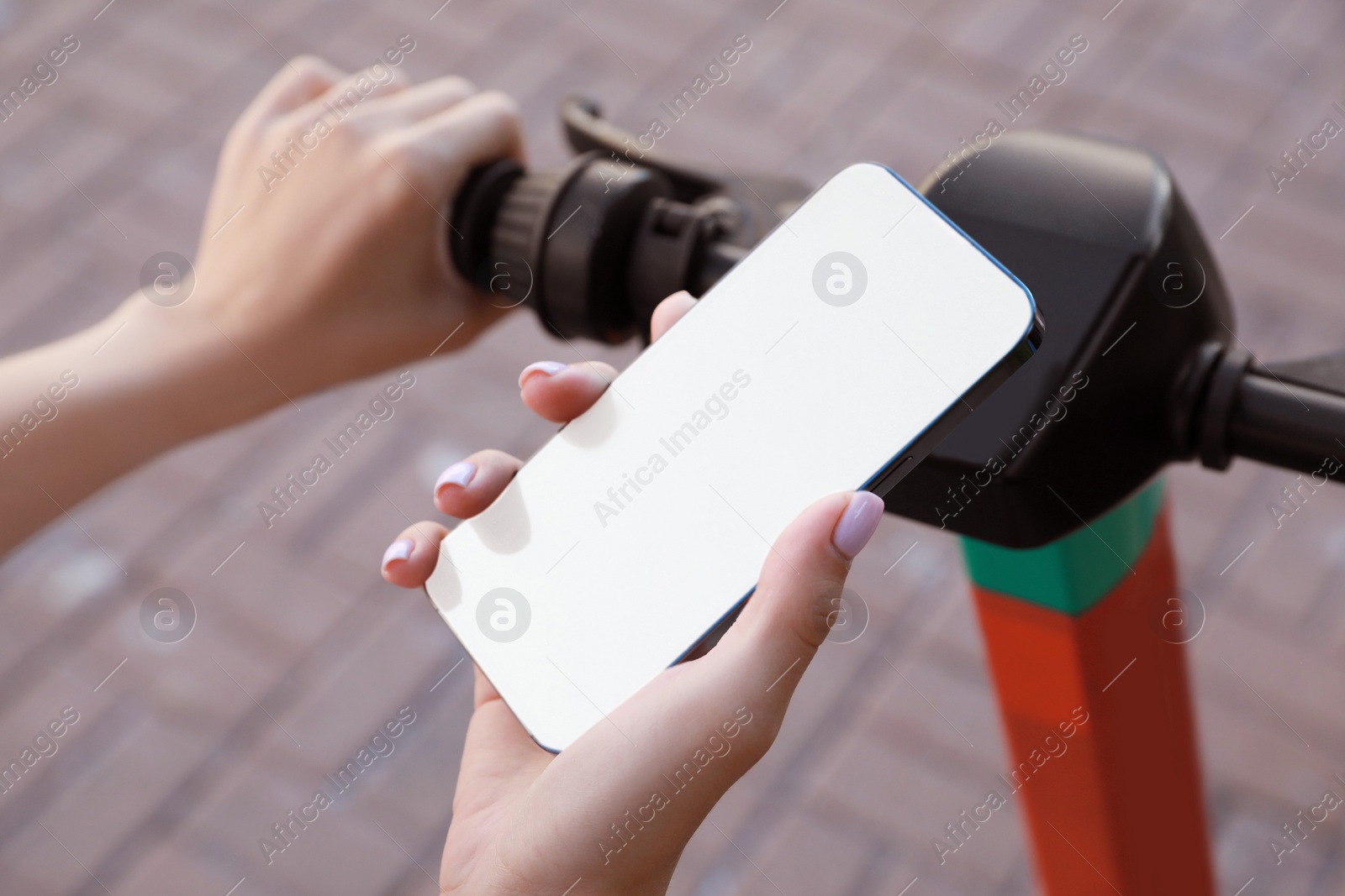 Photo of Woman using smartphone to pay and unblock electric kick scooter outdoors, closeup