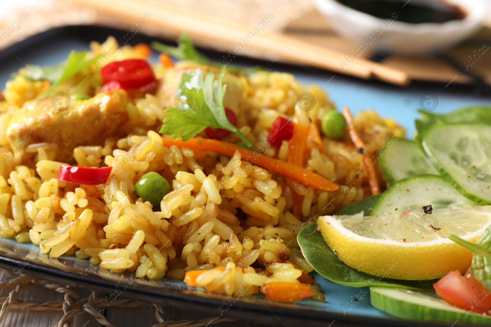 Photo of Tasty rice with meat and vegetables in plate on table, closeup