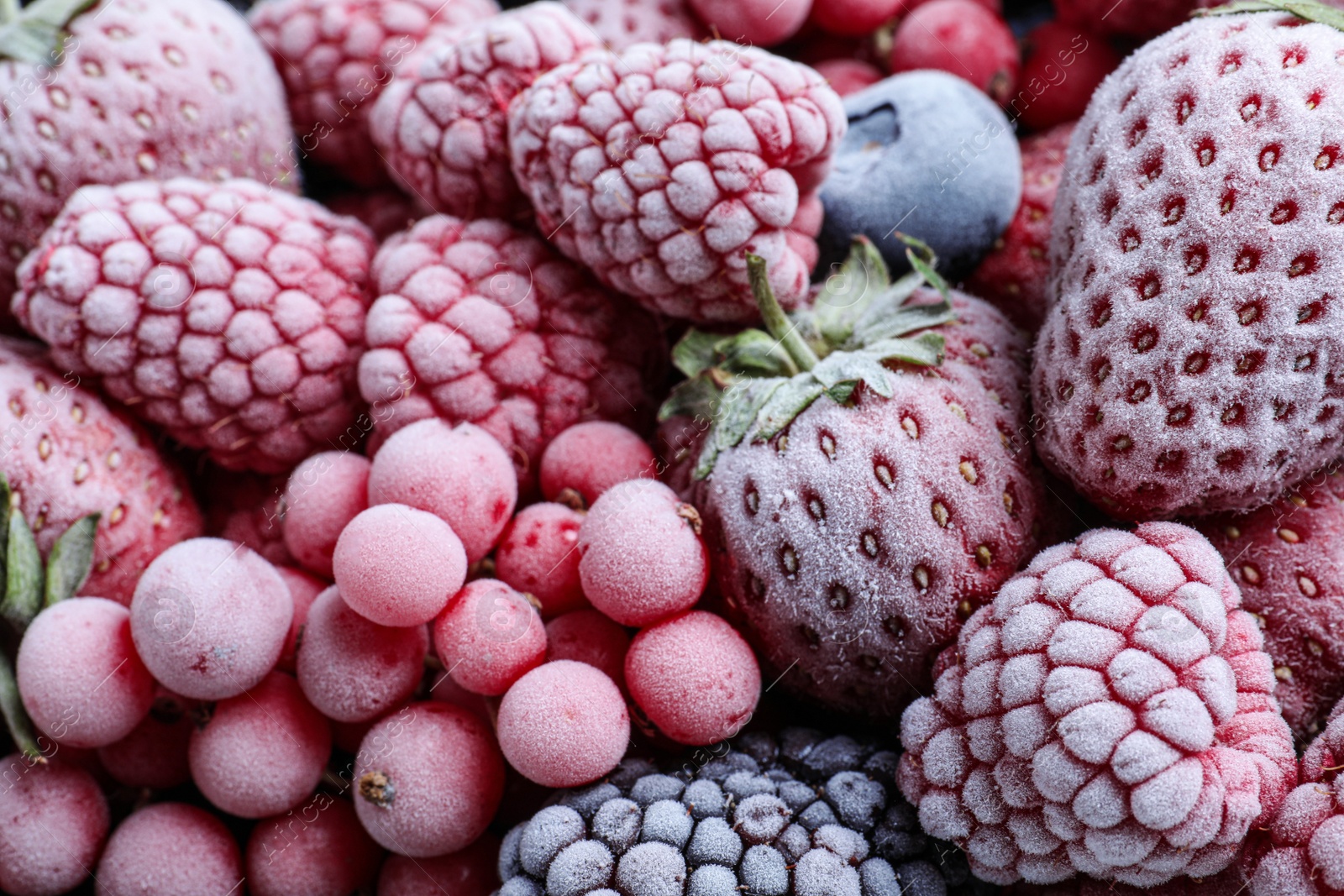 Photo of Mix of different frozen tasty berries as background, closeup