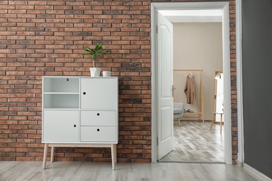 Photo of Room interior with stylish white cabinet and open door