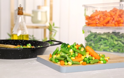 Board with mix of frozen vegetables on table