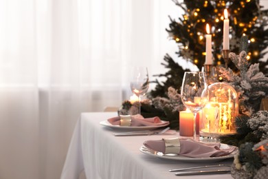 Beautiful festive table setting with Christmas decor in room, space for text