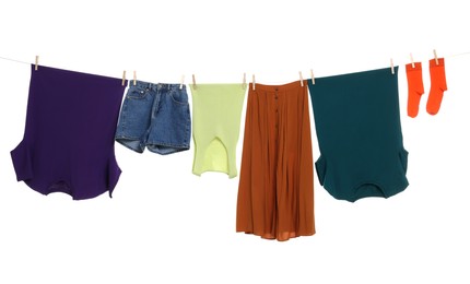 Photo of Different clothes drying on laundry line against white background