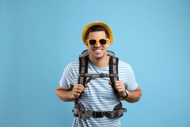 Male tourist with travel backpack on turquoise background