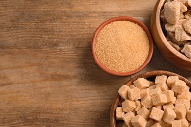 Photo of Different types of sugar on wooden table, flat lay. Space for text