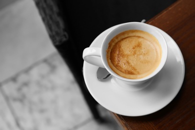 Cup of delicious aromatic coffee on table