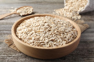 Photo of Bowl with raw oatmeal on wooden table