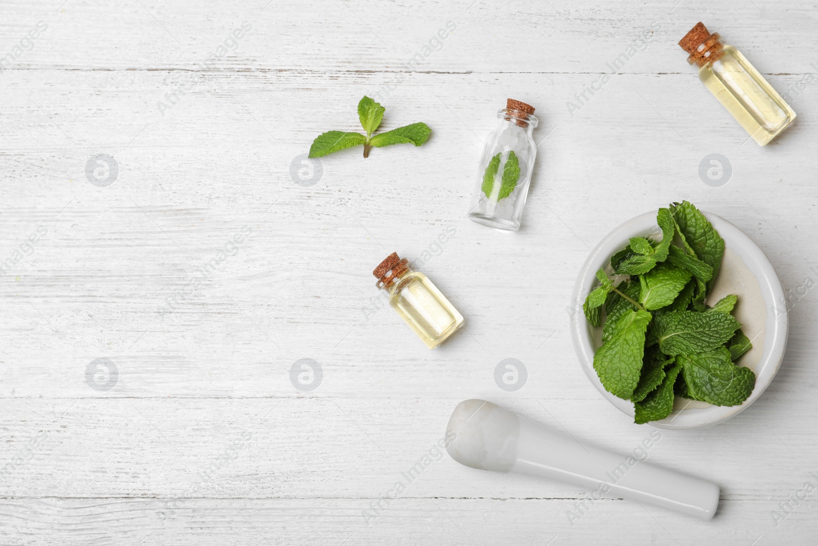 Photo of Essential oil, herb and space for text on wooden background, flat lay