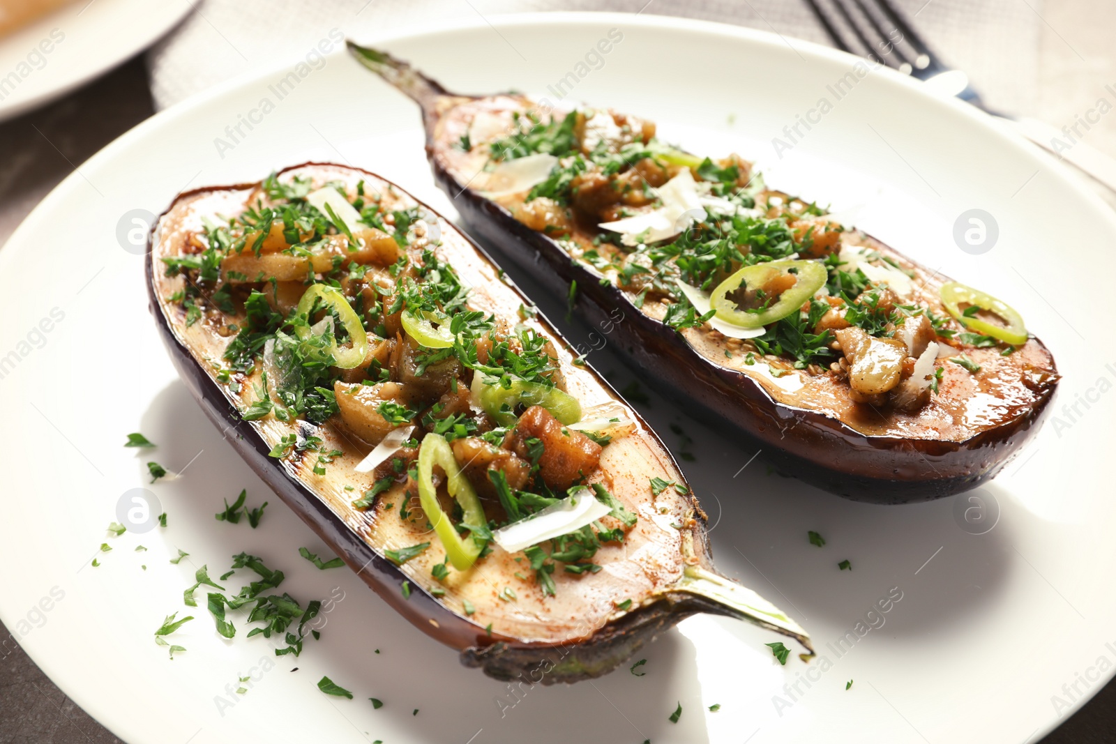 Photo of Plate with tasty stuffed eggplants, close up view